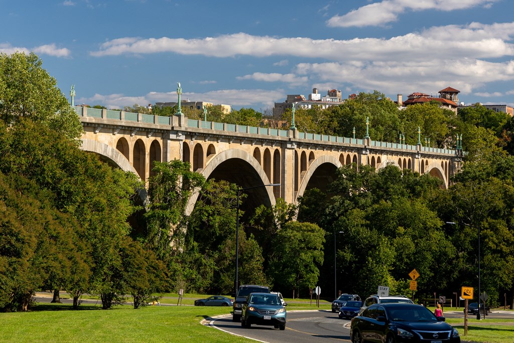 a bridge over a road with cars driving under it