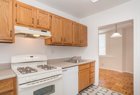 a kitchen with white appliances and wooden cabinets and a white stove