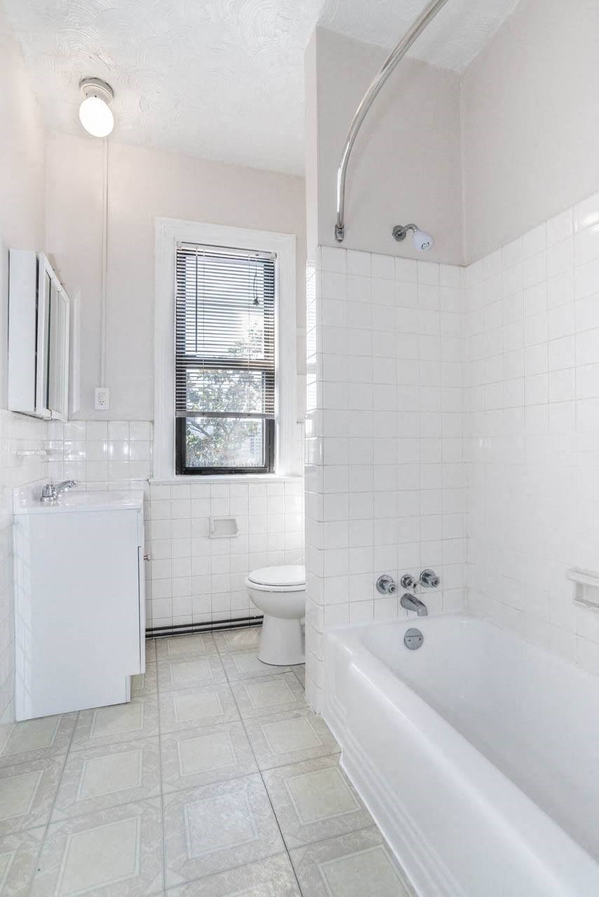 a white bathroom with a tub and a toilet and a sink