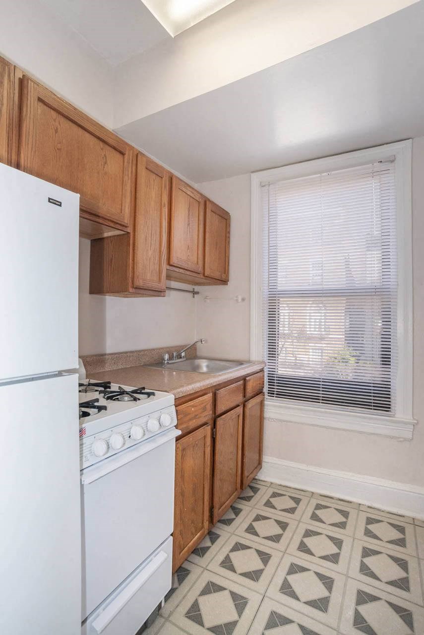 a kitchen with a stove refrigerator and sink  and a window