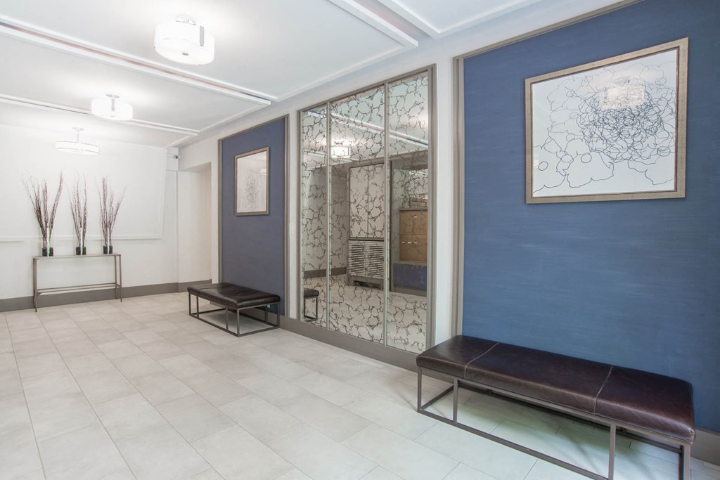 the lobby of a building with benches and a mirror