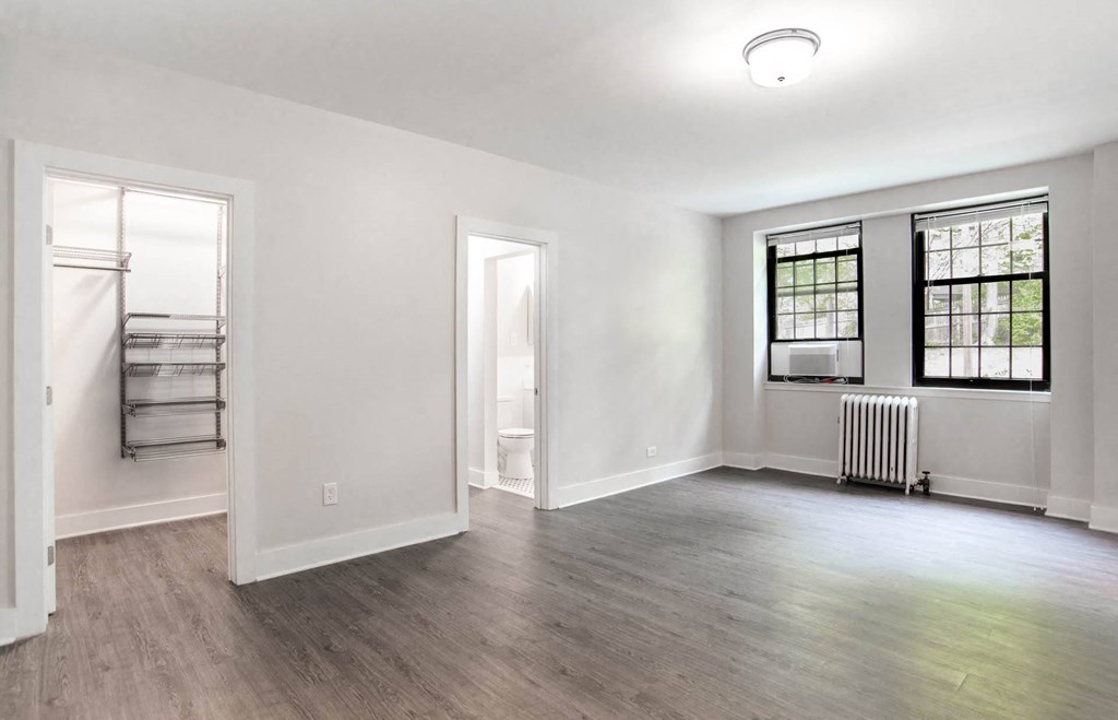 an empty living room with white walls and wood floors