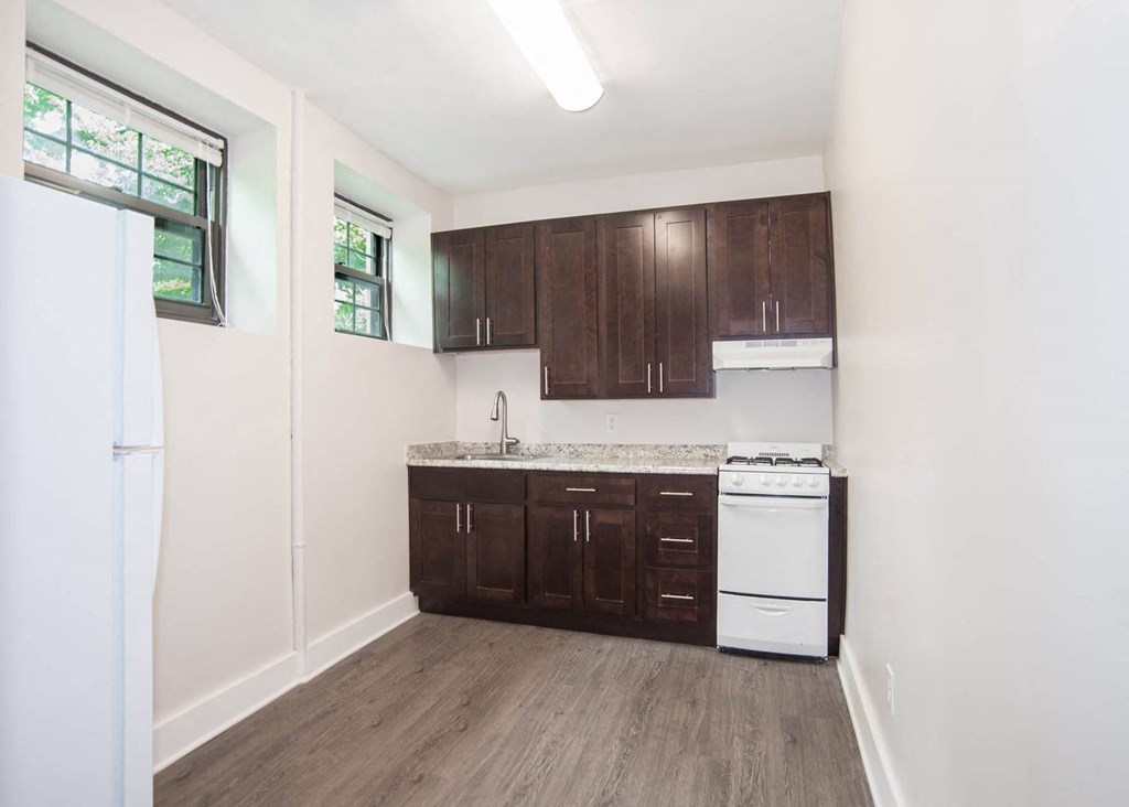a kitchen with white appliances and dark wood cabinets