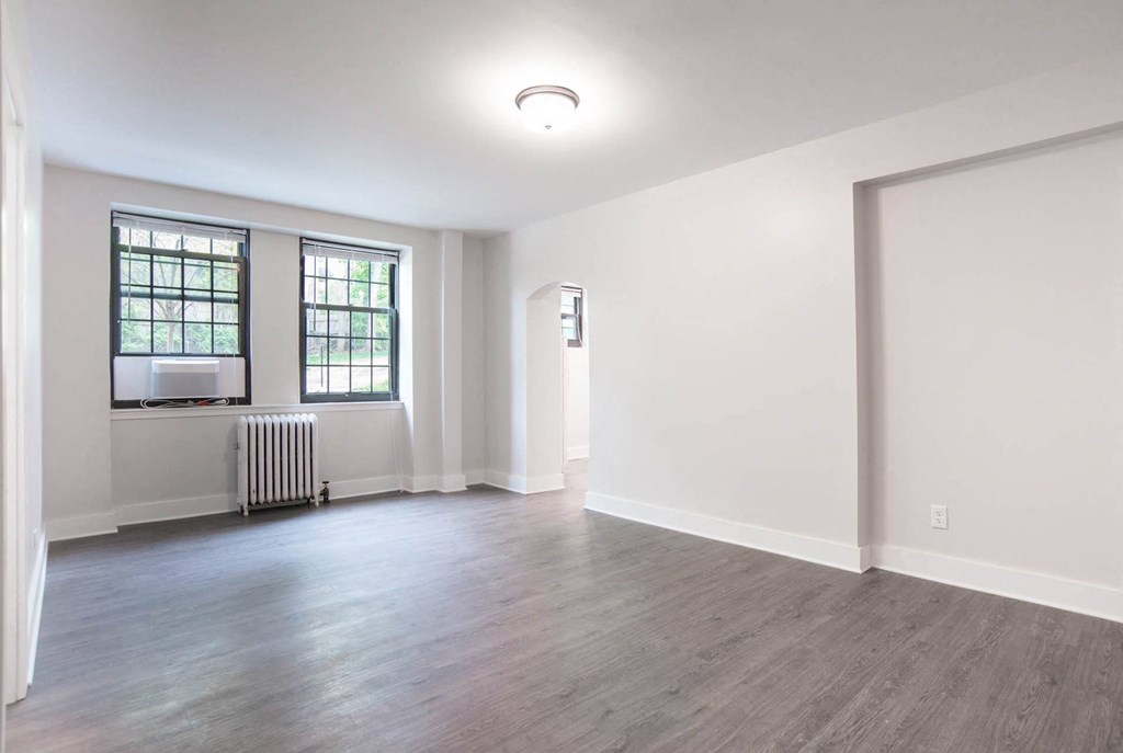 an empty living room with white walls and a window