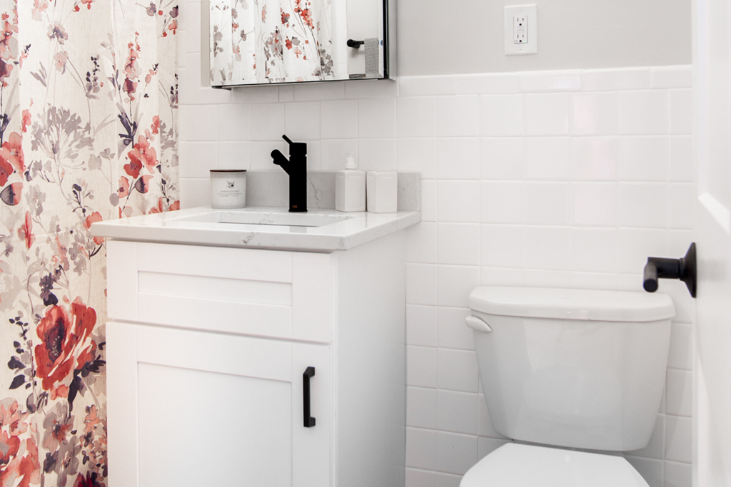 a white bathroom with a white toilet and a sink and a shower curtain