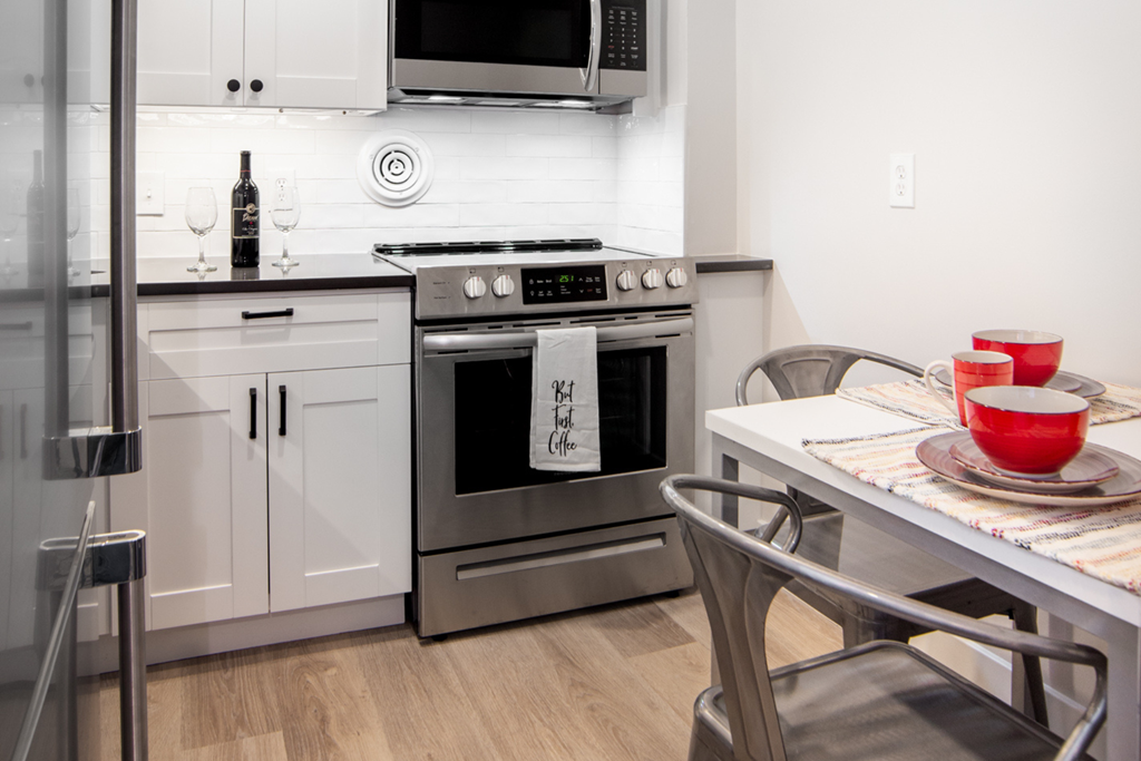 a kitchen with stainless steel appliances and a table with chairs