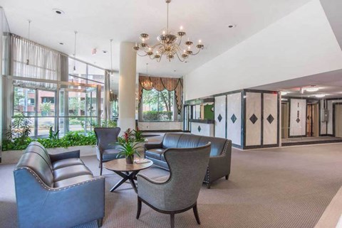 a lobby with couches and chairs and a chandelier