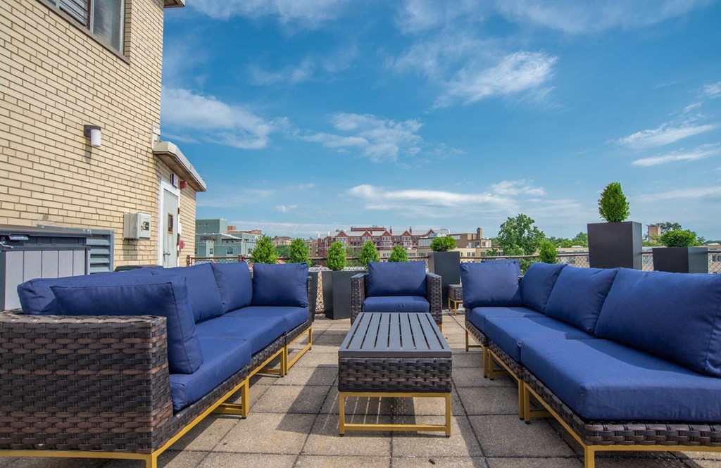 a rooftop patio with blue couches and a coffee table