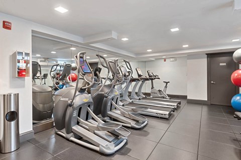 a gym filled with cardio equipment and weights