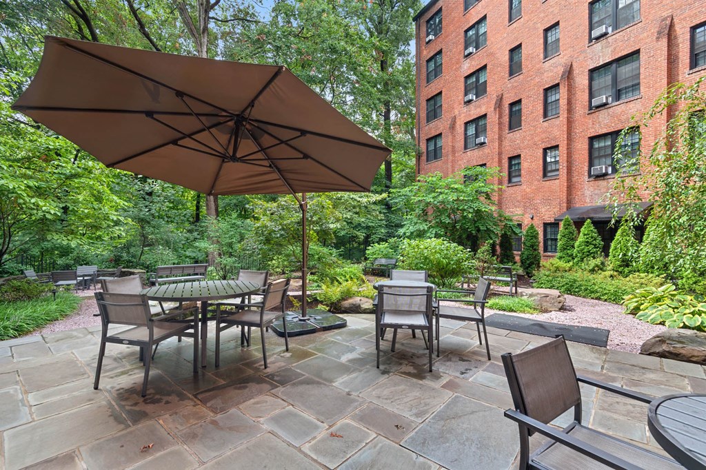 a patio with tables and chairs and an umbrella