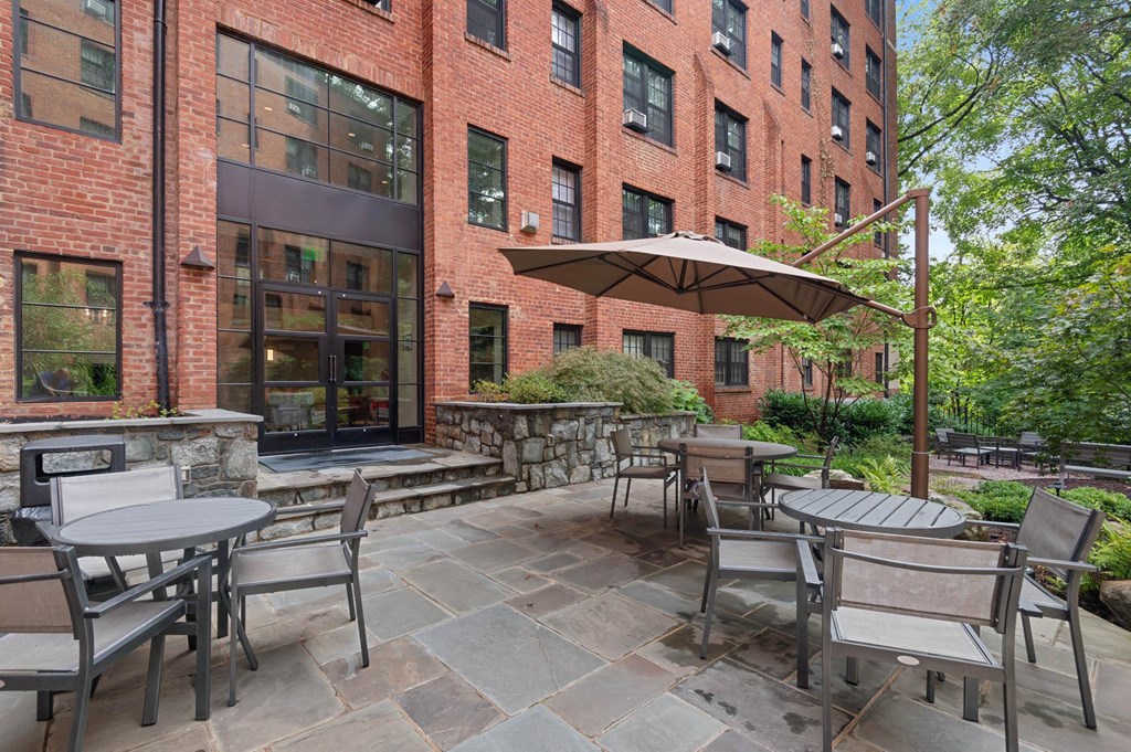 a patio with tables and chairs outside of a brick building