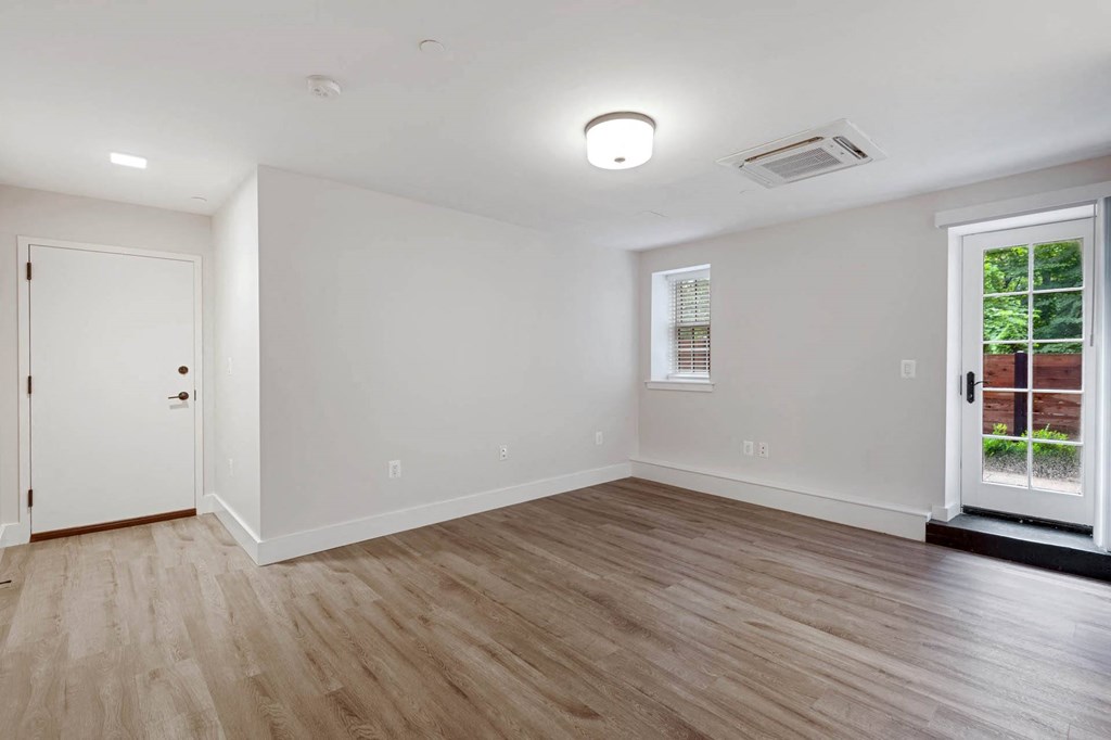 an empty living room with a window and a door