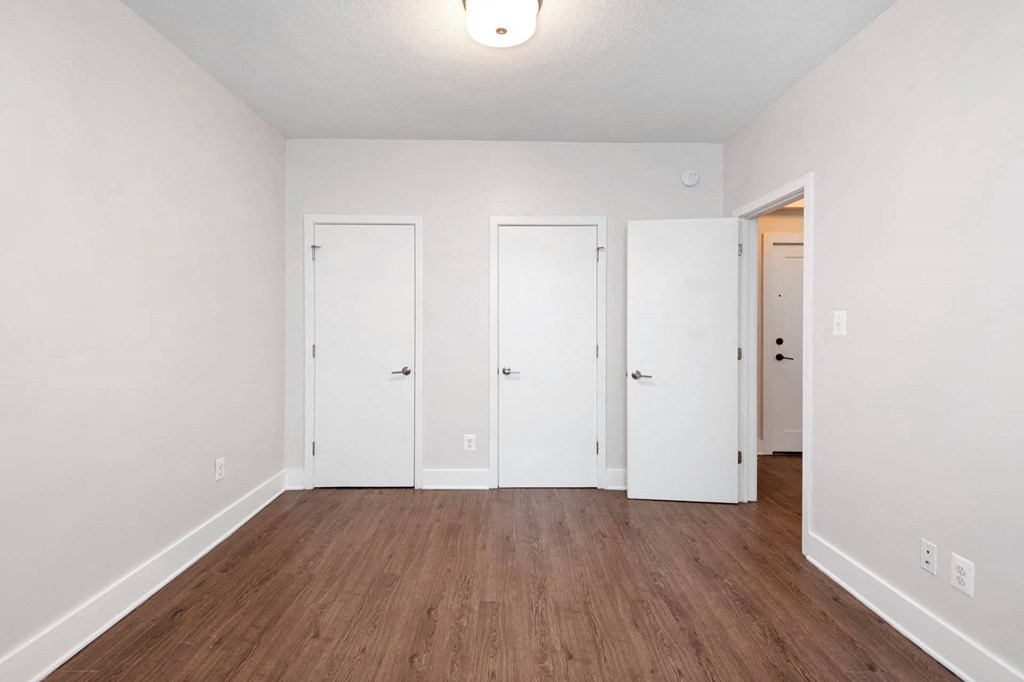 an empty living room with white walls and wood floors