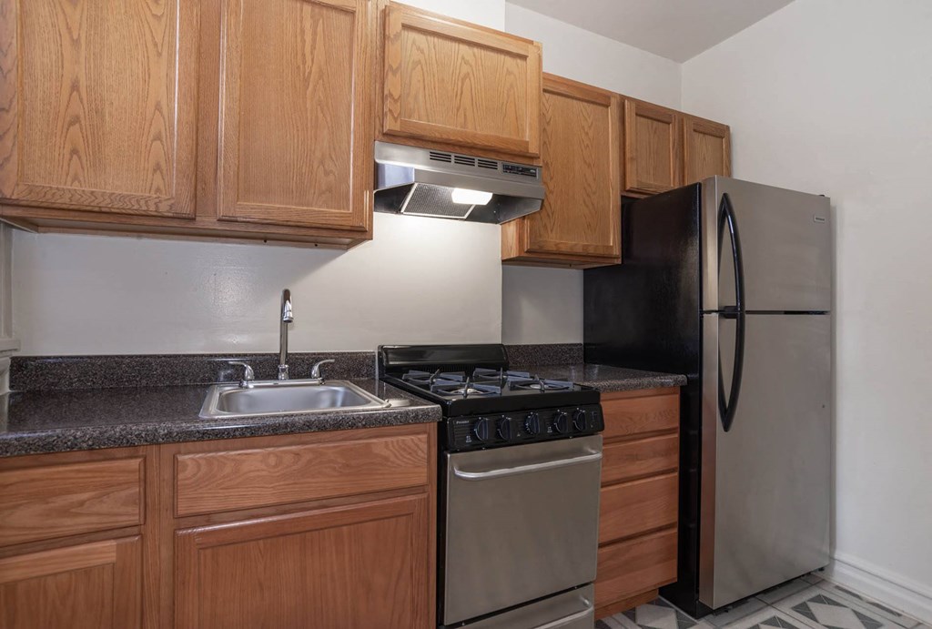 a kitchen with a stove refrigerator and sink