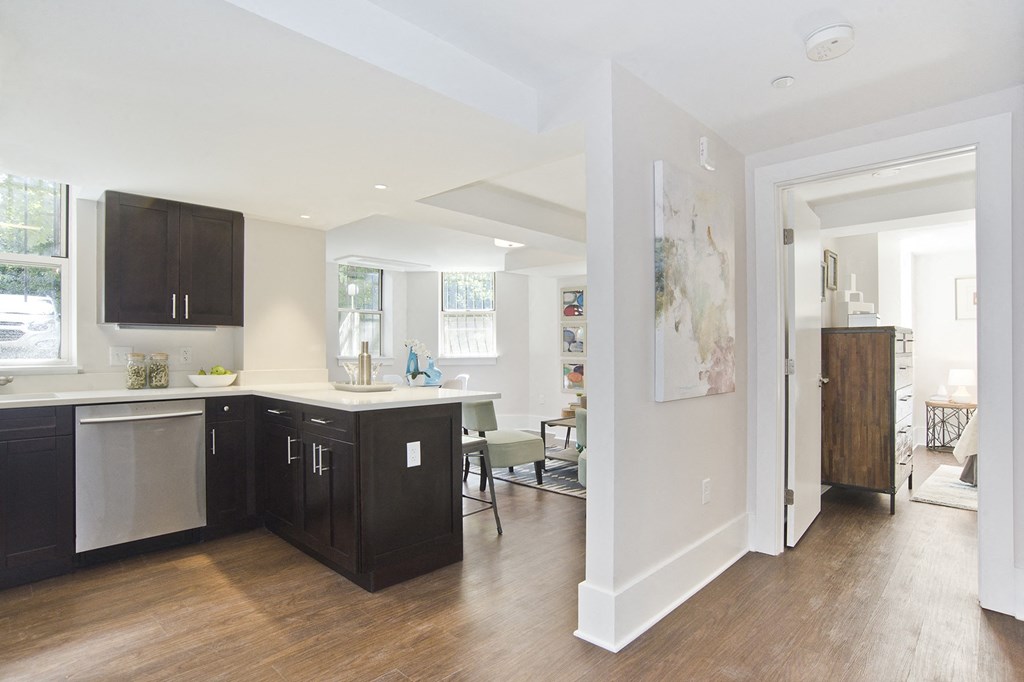 kitchen with black cabinets and a white counter top and a living room
