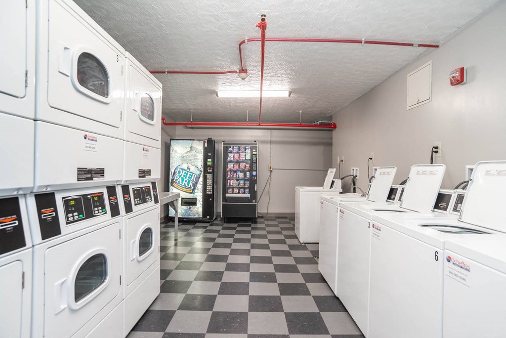 a laundry room filled with lots of white washing machines