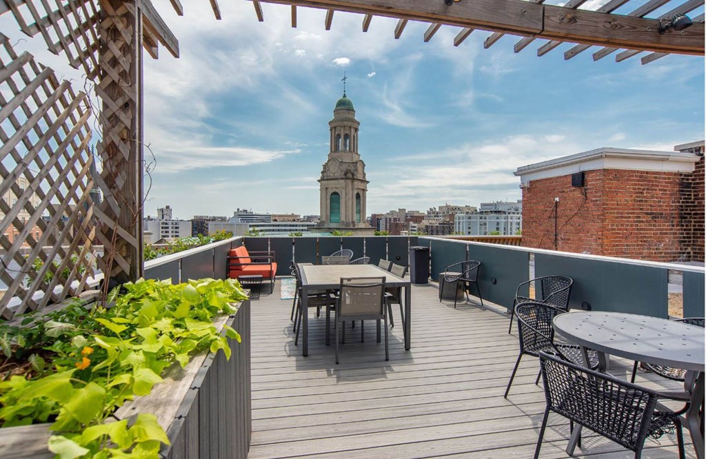 a roof terrace with tables and chairs and a view of the city