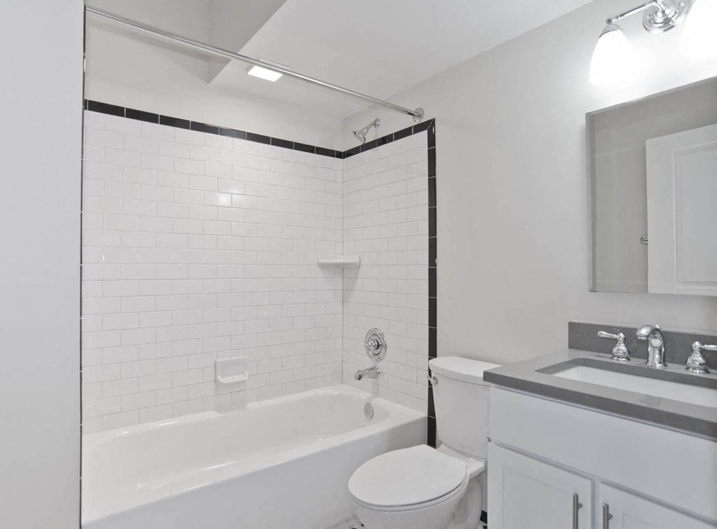 a white bathroom with a tub and a sink and a toilet