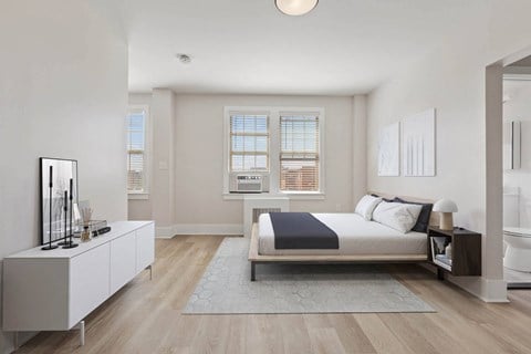 a white bedroom with a bed and a bathroom