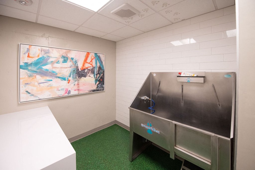 a small room with a refrigerator and a painting on the wall