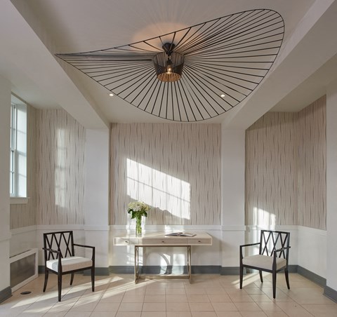 a lobby with a table and chairs and a large chandelier