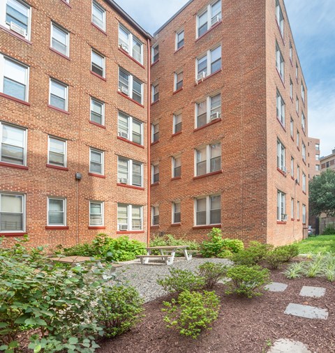 the courtyard of a brick building with a picnic table