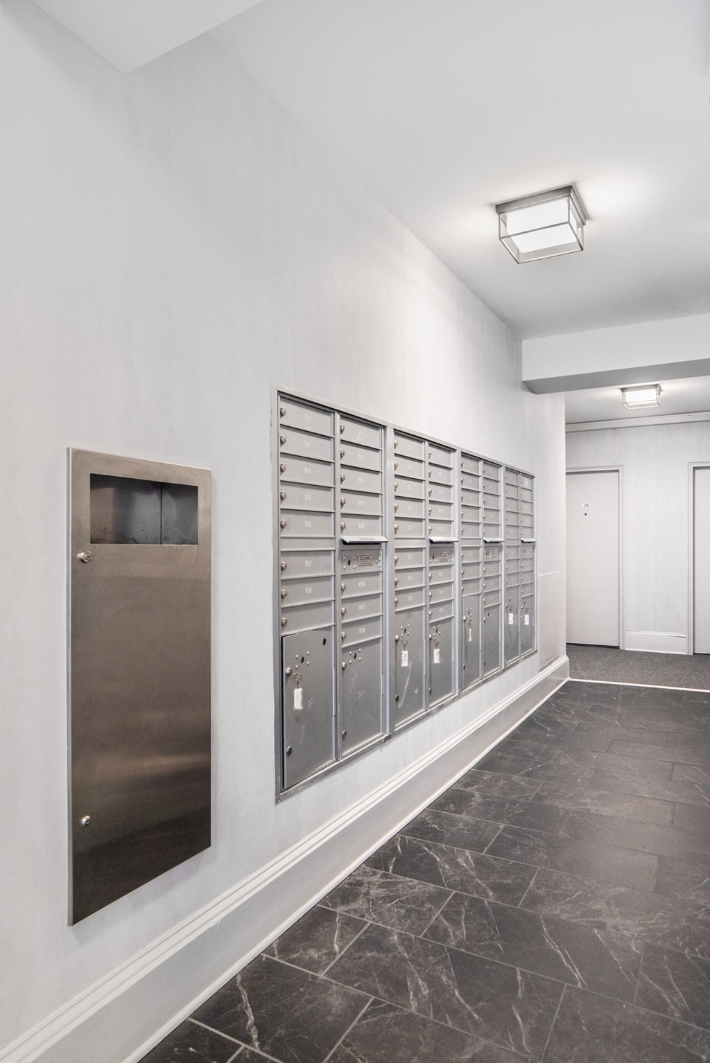 a view of the mail room of a building with mailboxes on the wall