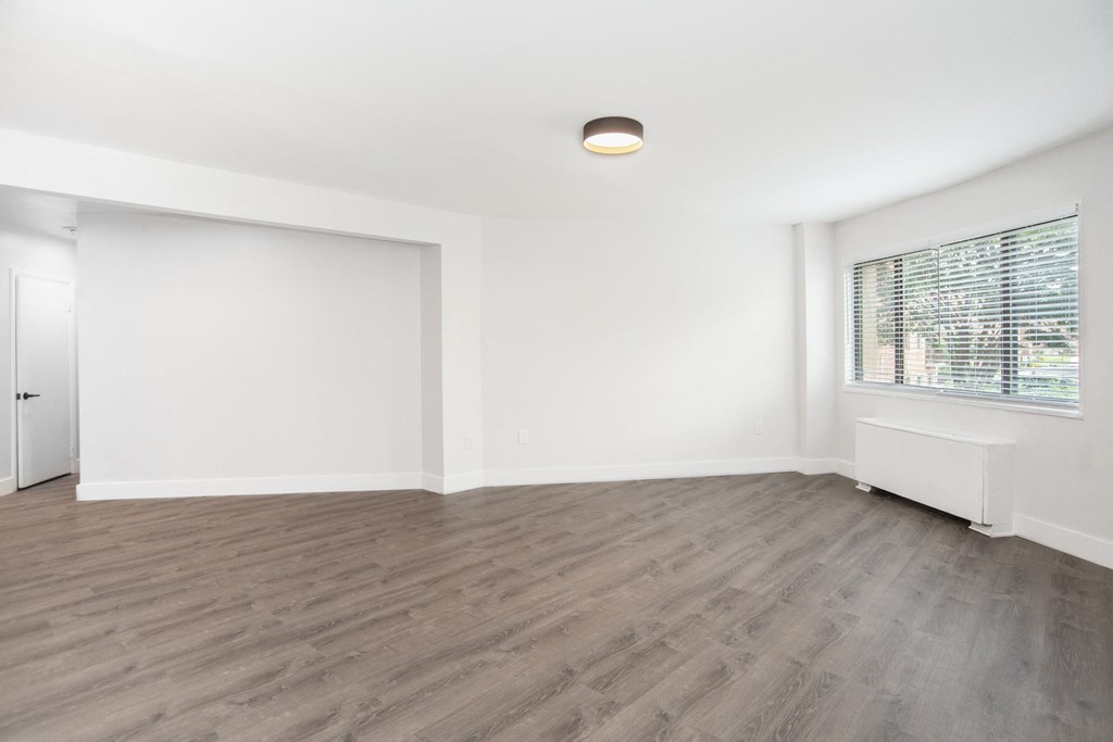a bedroom with hardwood floors and white walls