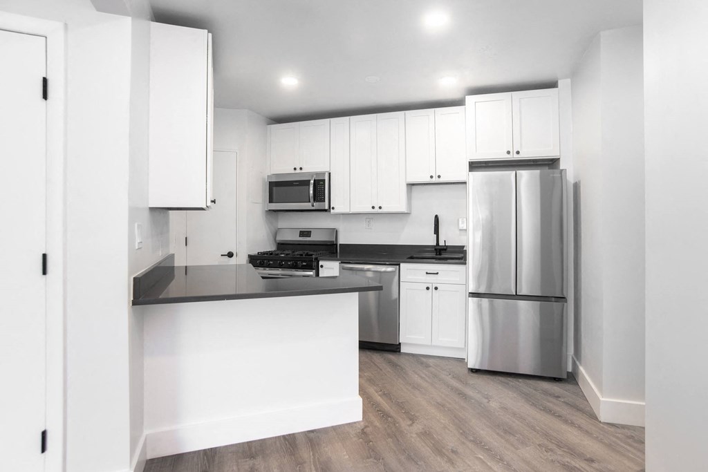 a kitchen with white cabinets and stainless steel appliances