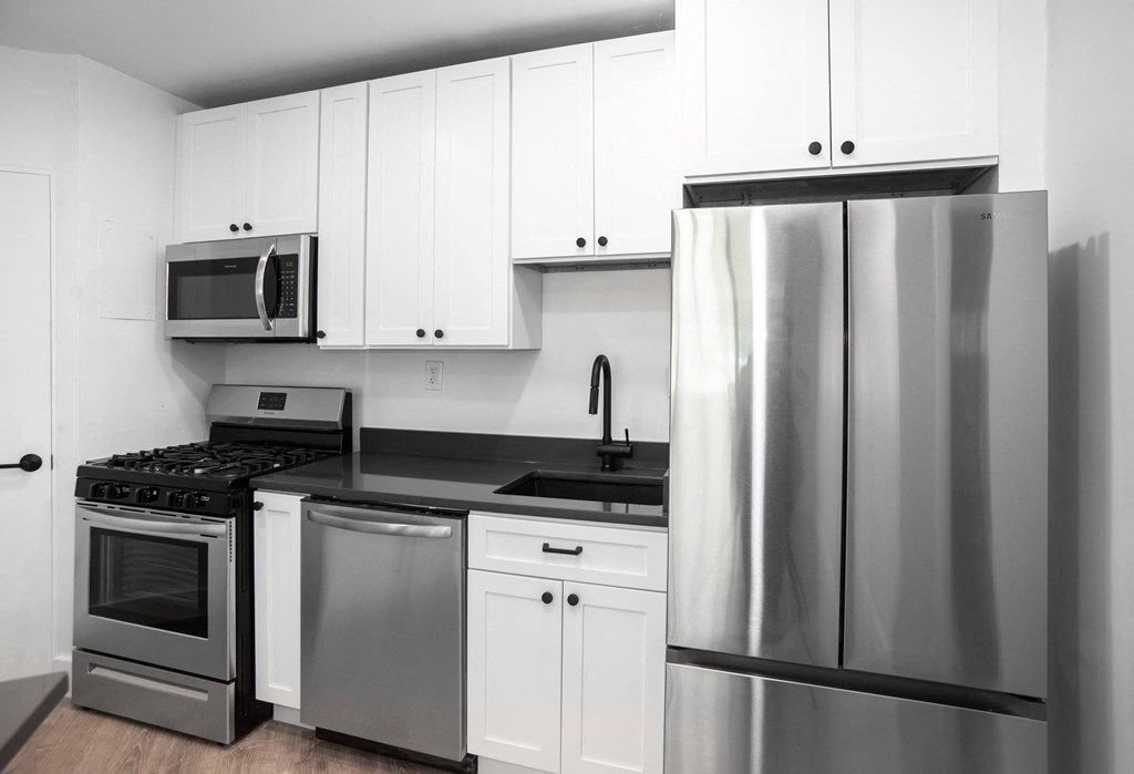 a kitchen with white cabinets and stainless steel appliances