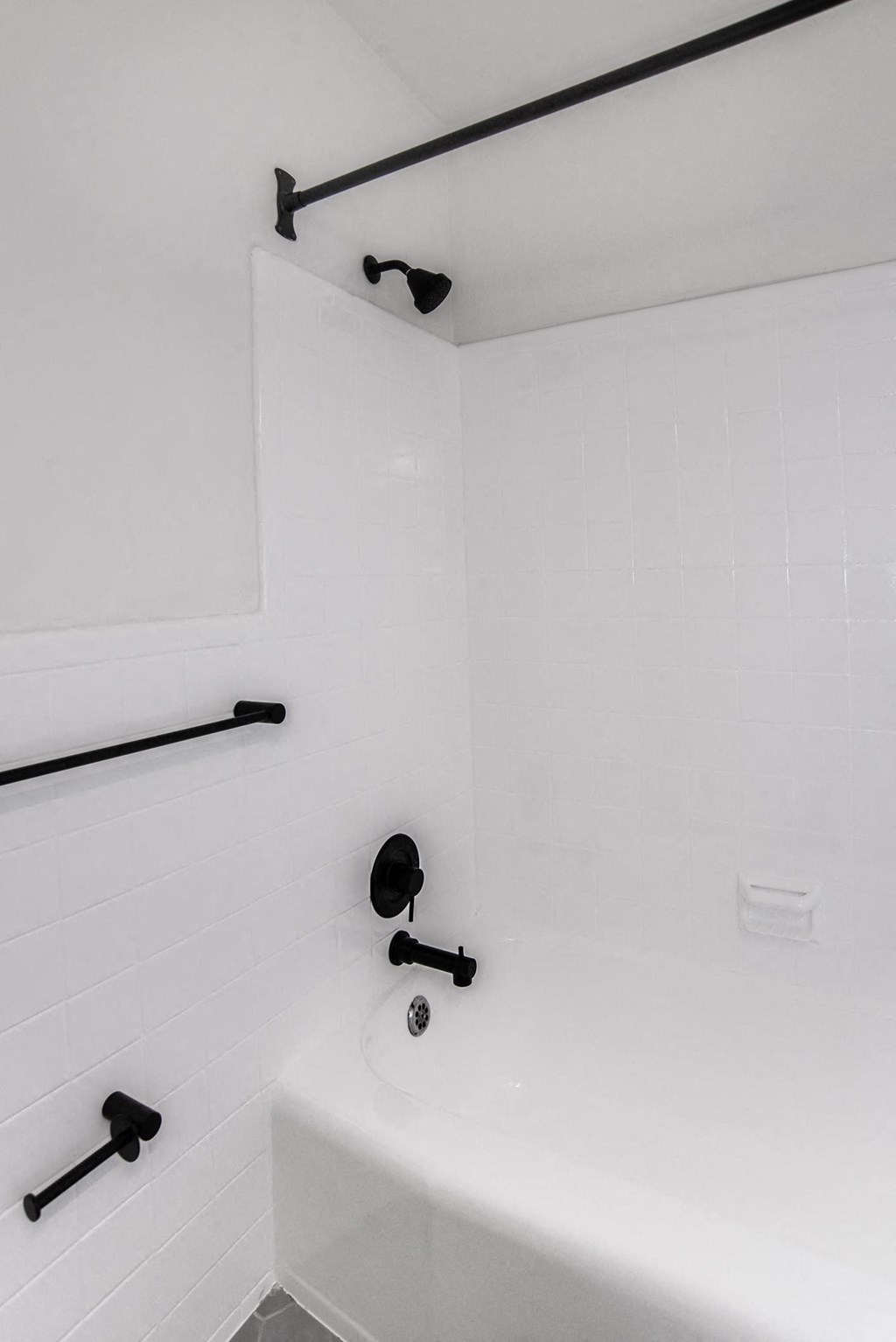 a bathroom with a white tub and a black shower curtain