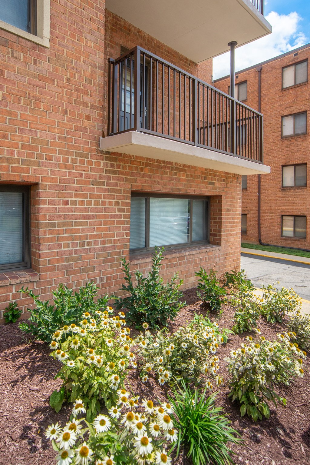 a flower bed in front of a brick building