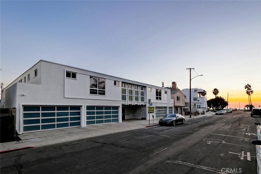 a white building with a car parked on a street
