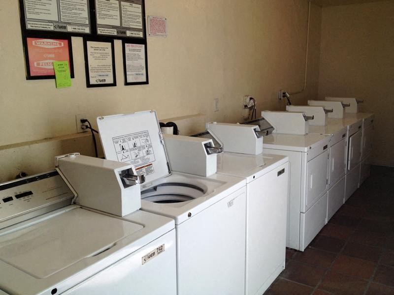 a group of washing machines and dryers in a room