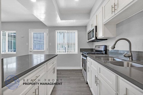 a kitchen with white cabinets and a sink