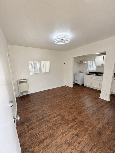 A room with a wood floor and a ceiling fan.