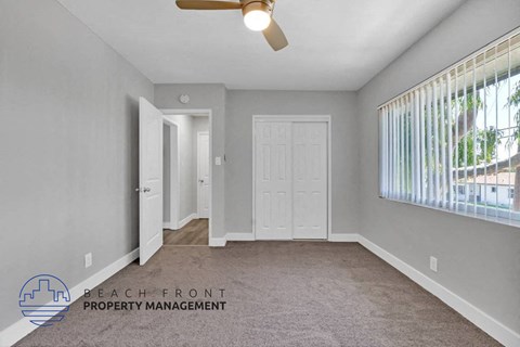 an empty living room with a white door and a window