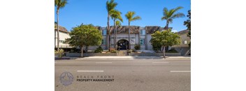 A building with palm trees in front of it and the words "Beach Front Property Management" on the bottom left.