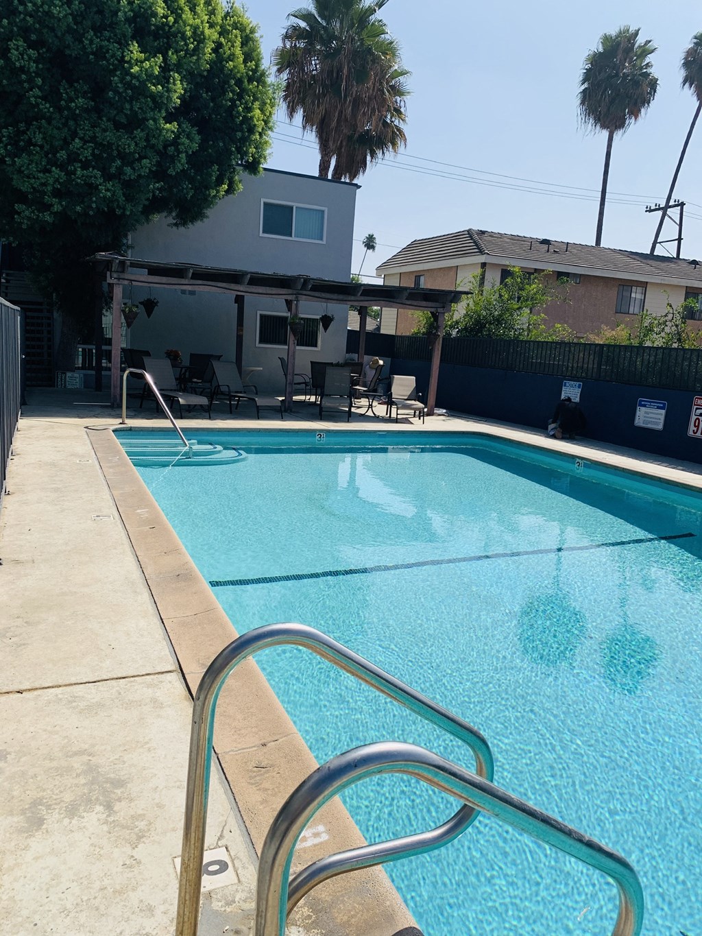 a swimming pool with a fence and a house in the background