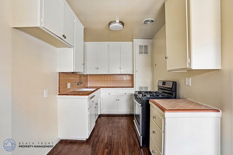 A kitchen with white cabinets and a wooden countertop.