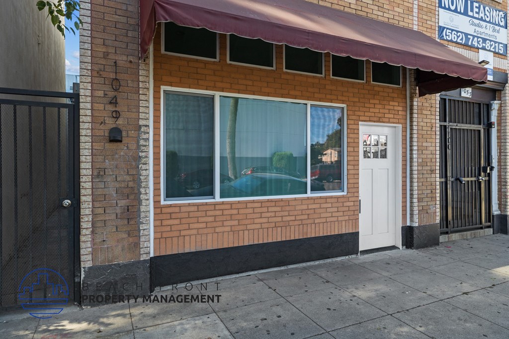 the front of a brick building with a window and a white door