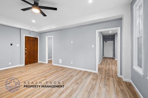 a renovated living room with wood flooring and a ceiling fan