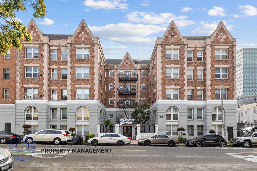 A large brick building with a parking lot in front of it.