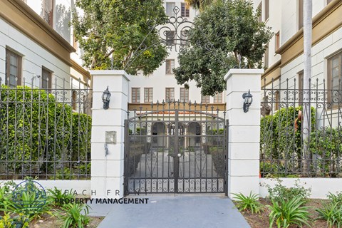 A gated entrance to a property with a sign that says Beachfront Property Management.