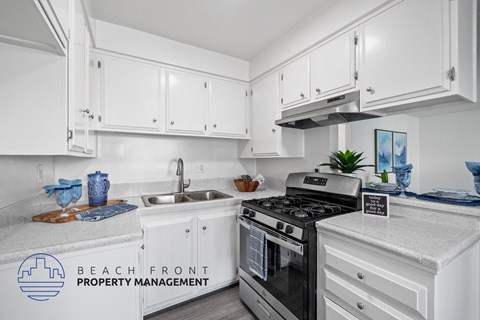 A kitchen with white cabinets and a stove top oven.