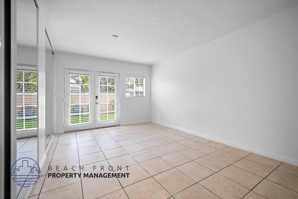 the living room of a house with a tiled floor and white walls