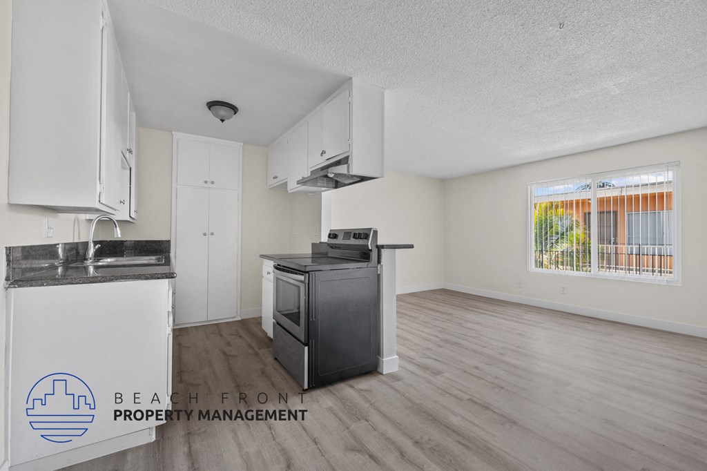 A kitchen with a stove top oven and a refrigerator.