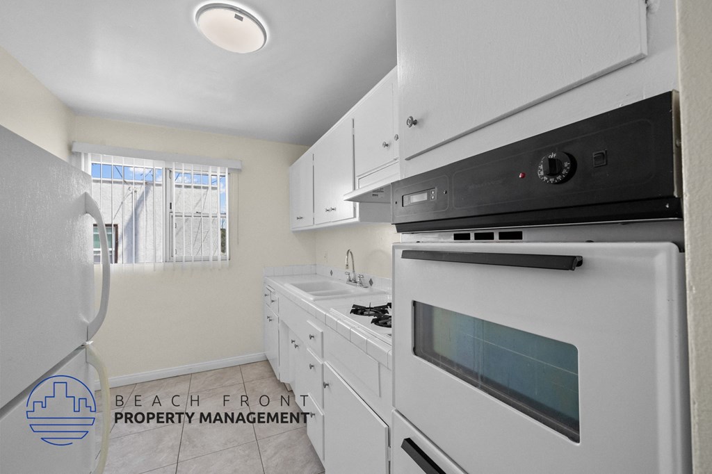 a white kitchen with a stove and a refrigerator