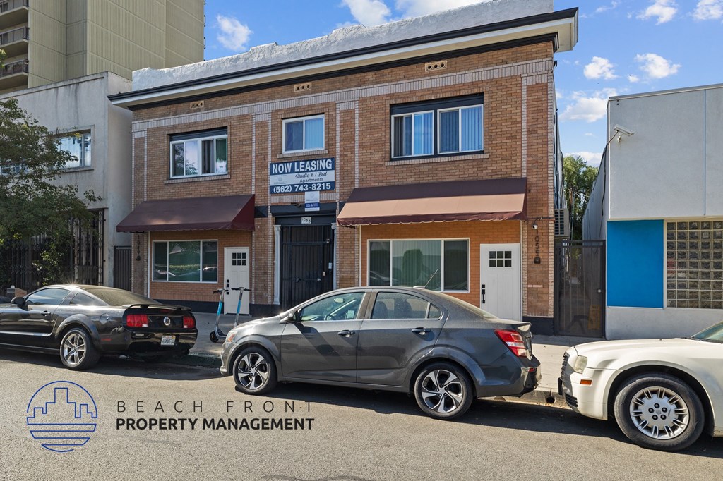 the front of the beach front property management office with cars parked outside