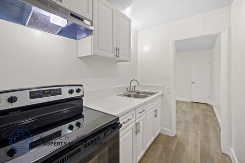 a kitchen with white cabinets and stainless steel appliances and a sink